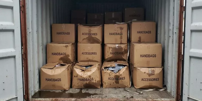 Damaged and crushed bag cartons with water stains due to container rain