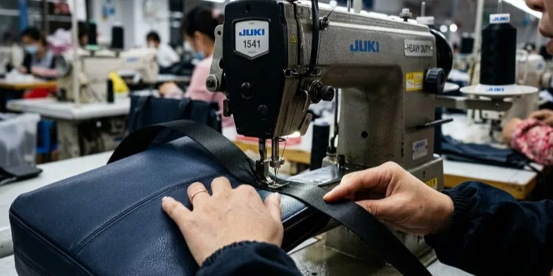 Inspector performing a 500-cycle zipper cycle test during final pre-shipment quality assurance.