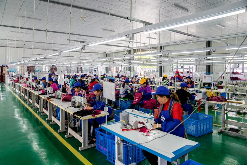 Skilled sewing operators on duffle bag production line