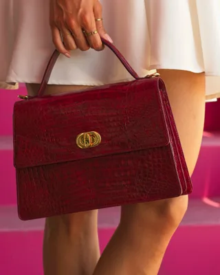 Woman in white dress carrying a red purse on city street