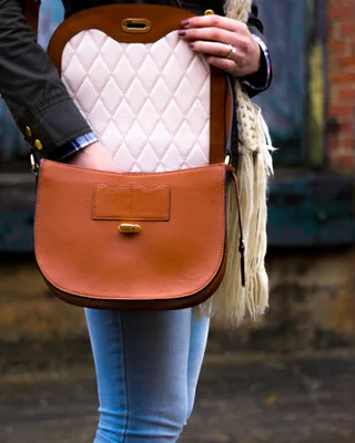 Woman wearing red leather crossbody bag outdoors