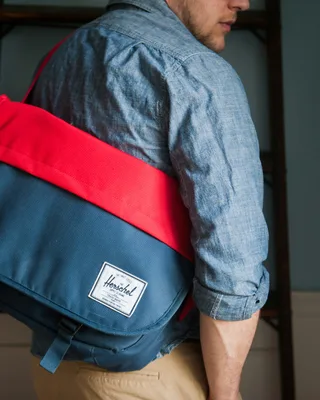 Man holding and carrying a bag on city street