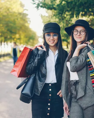Two women with shopping bags in a park